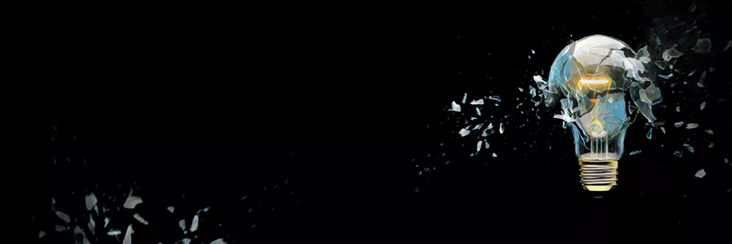A shattered light bulb disperses fragments against a black background, symbolizing the explosion of ideas and creativity.