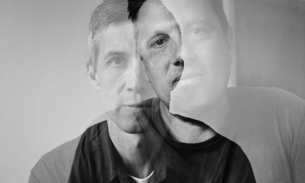 A double exposure portrait of two men, blending their features and expressions in a monochromatic style, creating an intriguing visual effect.