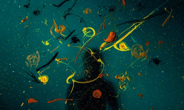 An abstract underwater scene featuring colorful paint swirls and a shadowy figure, creating a sense of depth and artistic expression.