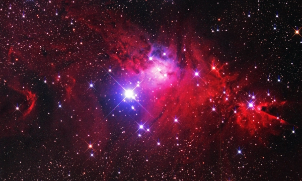 A vibrant cosmic scene showcasing bright stars surrounded by colorful nebulae, with shades of red, purple, and scattered starlight against a backdrop of deep space.