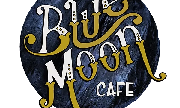 A circular logo for "Once in a Blue Moon Café" featuring artistic lettering in blue, white, and gold on a dark background.