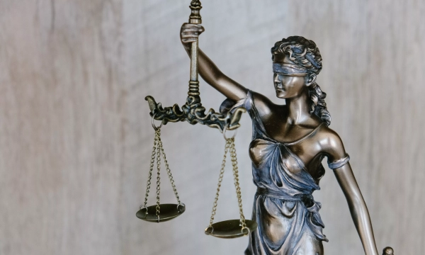 A bronze statue of Lady Justice, depicted blindfolded, holding a pair of scales, symbolizing fairness and the moral force of the law.