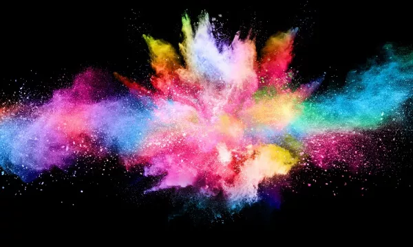 A vibrant explosion of colorful powders creating a dynamic, abstract design against a black background.