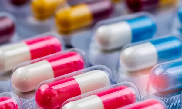 A close-up view of colorful capsules in various colors and patterns, arranged closely in a pill blister pack.