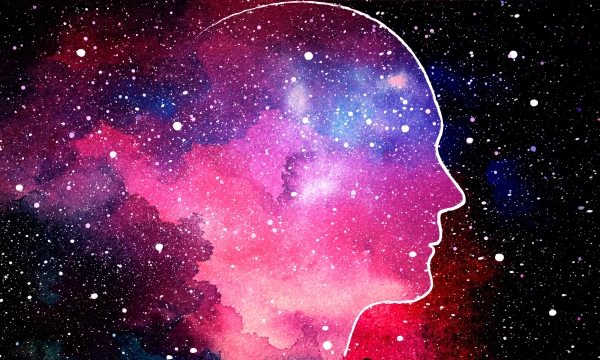 A silhouette of a human head filled with a vibrant cosmic scene of stars and colorful nebulae, symbolizing the connection between consciousness and the universe.