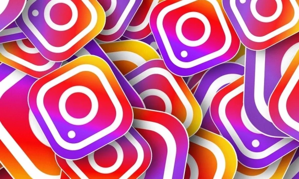 A colorful collection of Instagram logos featuring various shades of pink, orange, and purple arranged in overlapping layers.