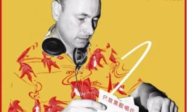 A man named Andy Smith, wearing a colorful shirt, is examining vinyl records while wearing headphones, promoting an event in London.