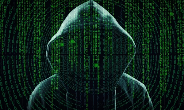 A hooded figure surrounded by swirling green binary code, representing themes of hacking, cybersecurity, and digital anonymity.