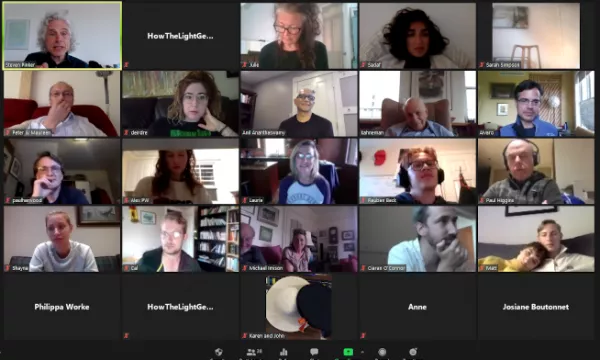 A diverse group of individuals participating in a virtual meeting, with some engaging in discussion and others listening attentively, displayed on a grid format.
