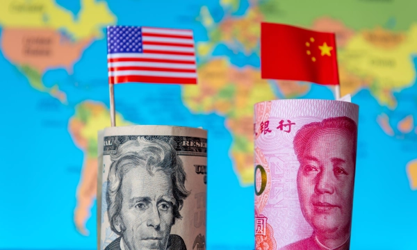 U.S. and Chinese banknotes displayed with their respective flags on a colorful world map background, symbolizing economic rivalry.