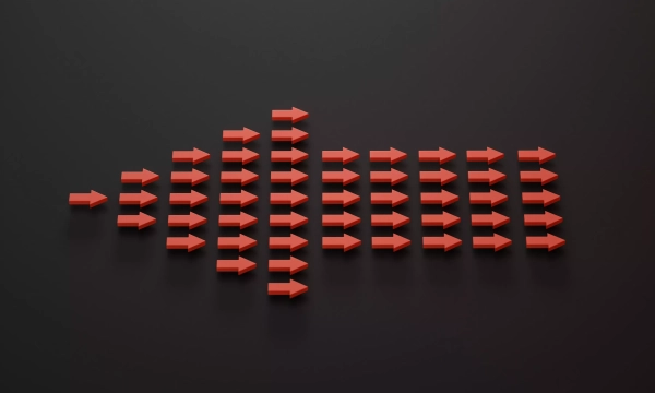 A visual representation of sound waves created with red arrows, arranged in increasing size, set against a dark background.