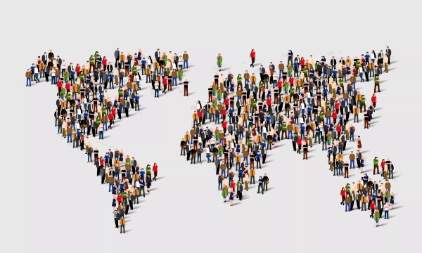 A large group of diverse people arranged to form a world map, illustrating global unity and diversity.